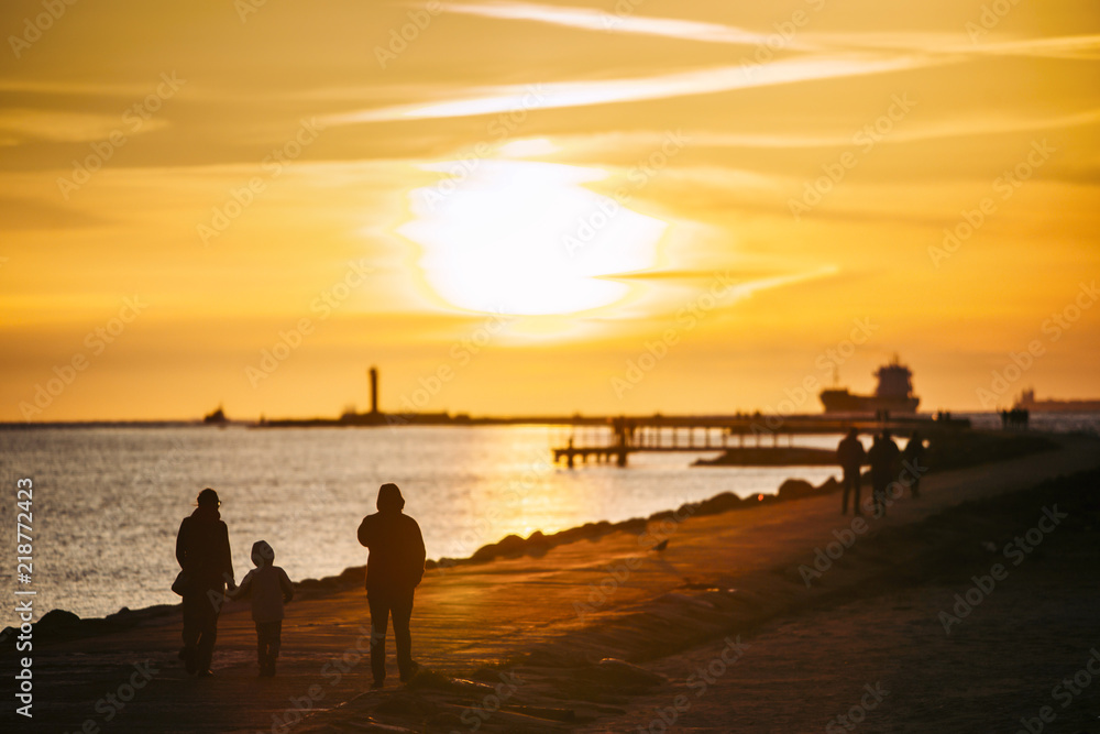 People walking on a pier on sunset