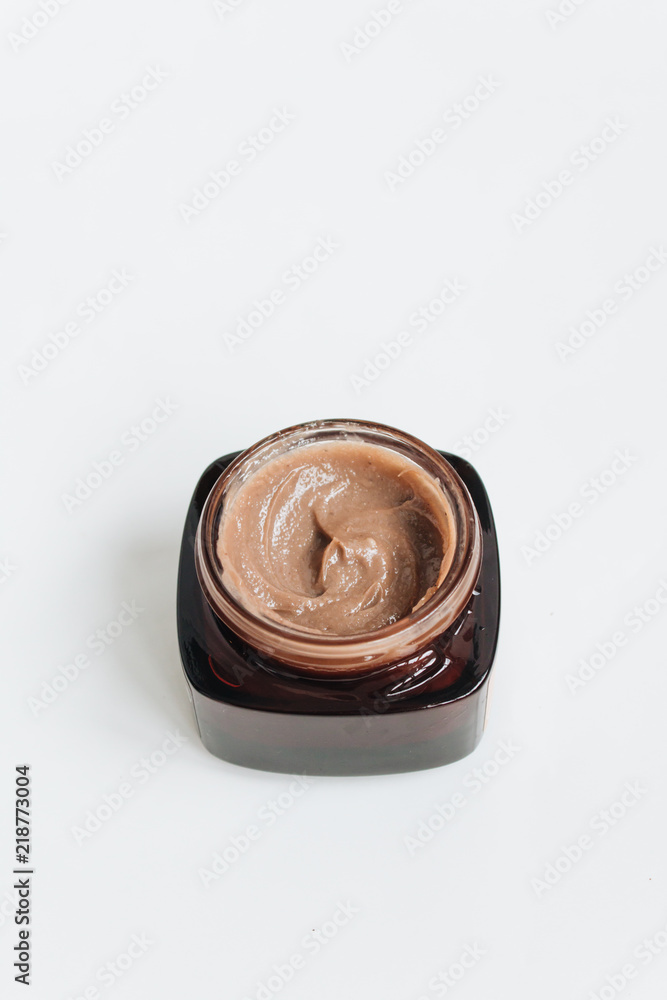 Chocolate cream in small jar on white background