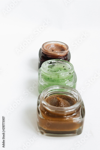 Assortment of different jams in small jars on white background