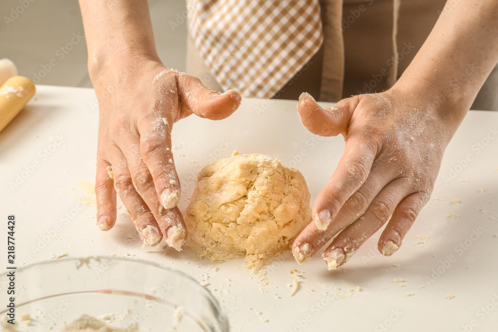 Woman kneading dough at light table Woman kneading dough at light table