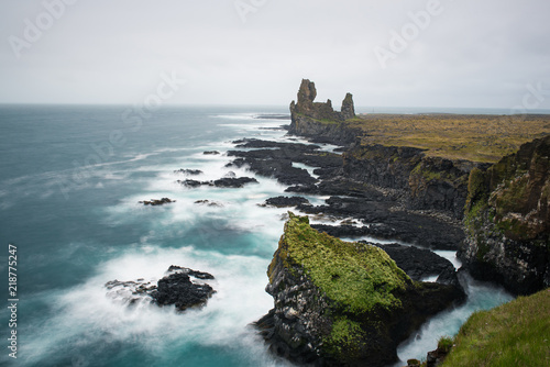 Dramatic scandinavian sea landscape with big cliffs and moody sky. Iceland outdoor travel background. Long exposure