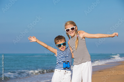 Two happy children playing on the beach at the day time