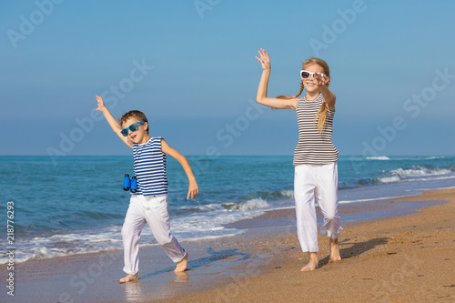 Two happy children playing on the beach at the day time