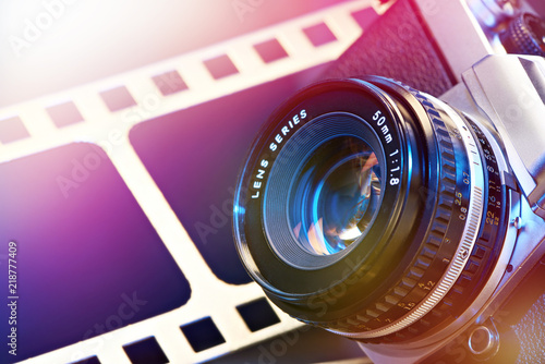 Obraz na plátně Lens SLR camera on background of perforation film