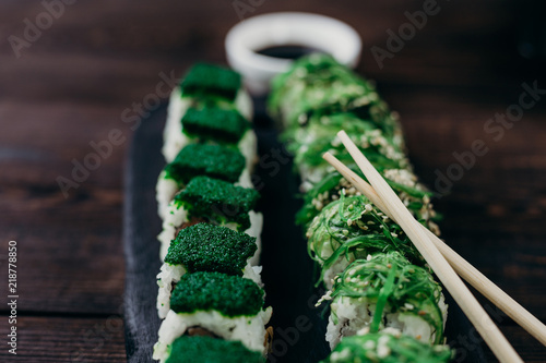 Wallpaper Mural Japanese sushi rolls served on black wooden tray. Fresh appetizing set served with sauce and chopsticks. Healthy food, traditional Asian seafood. Torontodigital.ca