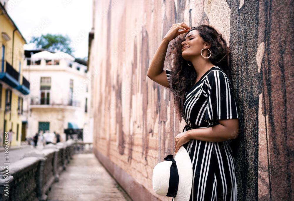 The beautiful streets of Havana in Cuba get young lady with black and white dress hypnotized.