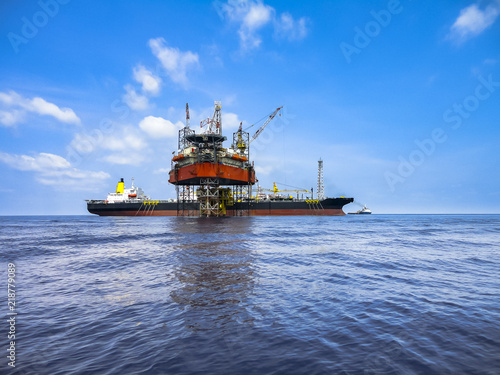 Photos Jack up drilling rig on oil well platform with FPSO ship on site with beautiful