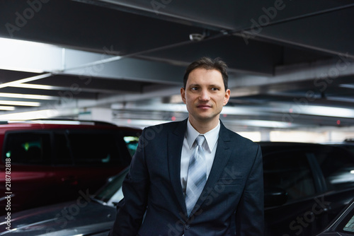 Handsome, attractive young happy, smiling, businessman closeup face portrait standing in indoors parking lot in suit and tie on interview break © Andriy Blokhin