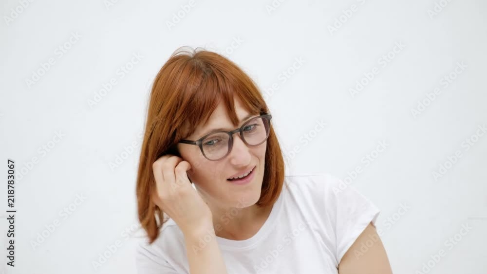 Woman putting ear plugs into her ears getting rid on noise in loud place. White background Woman putting ear plugs into her ears getting rid on noise in loud place. White background
