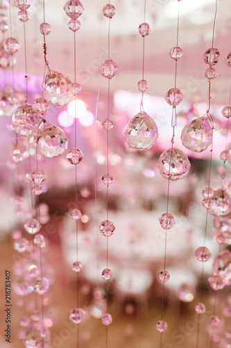 Chandelier light in interior, Chrystals close-up. crystal part from chandelier. Pink colors