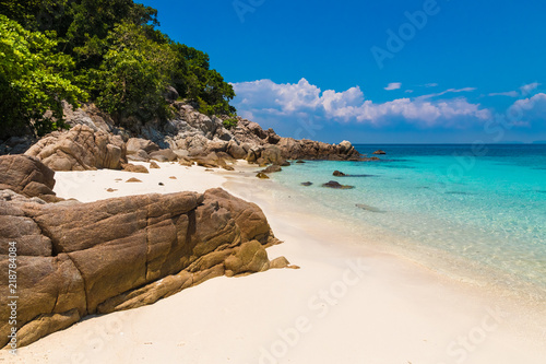 Beautiful stretch of a fine soft white sandy beach, turquoise blue shimmering water, big rocks & lush trees which belongs to Rawa Island, a popular snorkeling spot near Perhentian Kecil in Malaysia. photo