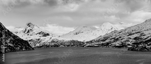 Landscape with beautiful winter lake and snowy mountains at Lofoten Islands in Northern Norway. Panoramic view, black and white