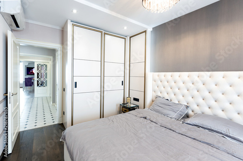 Modern bedroom interior with a big bed and a Chandelier