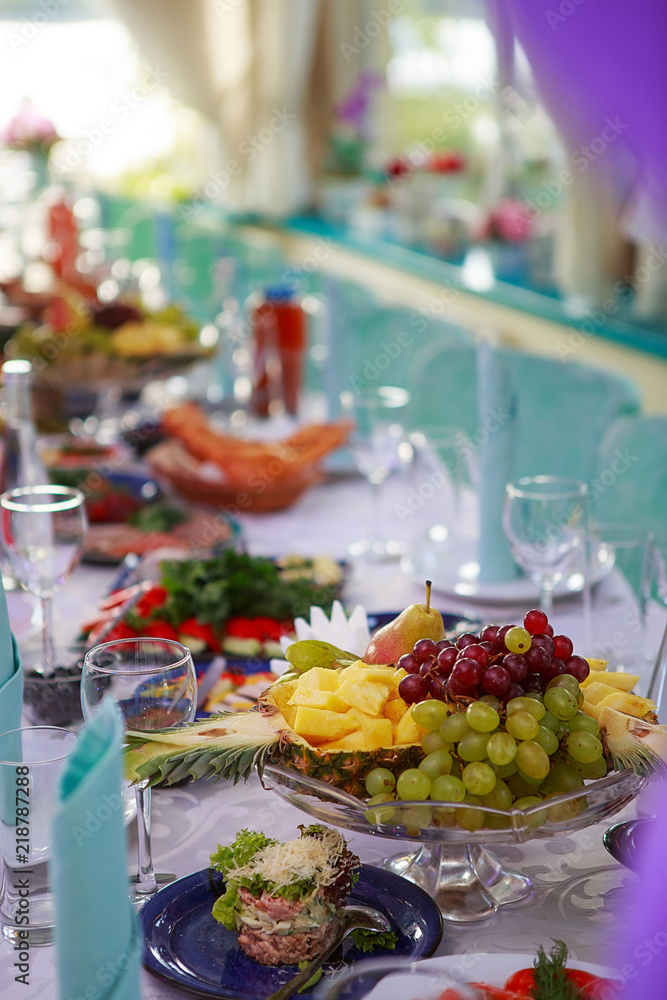 a furnished table for a party. On the table are clean dishes, fresh fruit and drinks. style in tiffany color