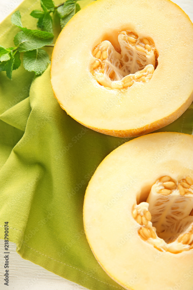 Halves of ripe melon on table