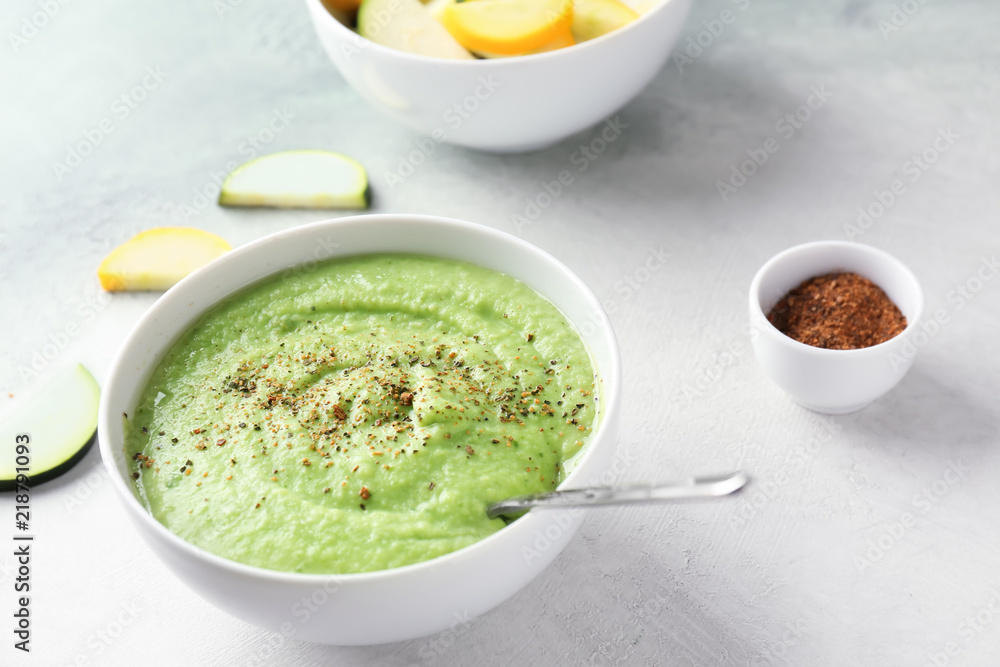 Tasty zucchini soup in bowl on light table Tasty zucchini soup in bowl on light table