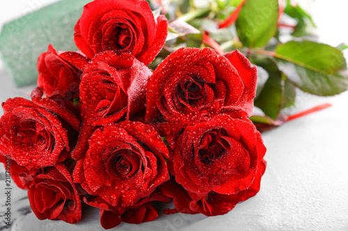 Beautiful bouquet of red roses on table  closeup