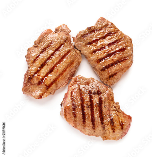 Tasty grilled steaks on white background