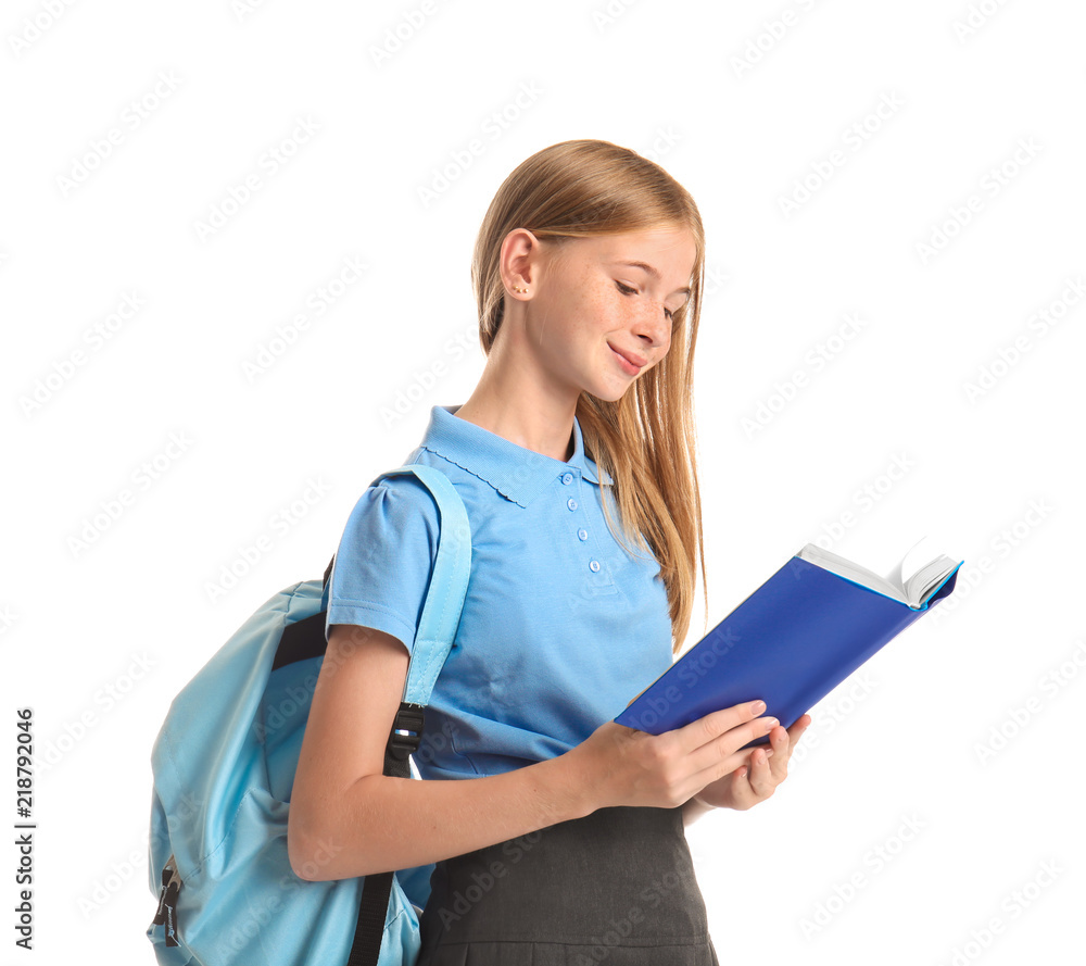 Cute schoolgirl reading book against white background