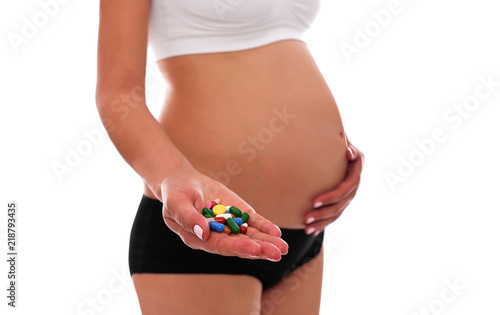 Tablets during pregnancy. In the female hands against the background of the abdomen.
