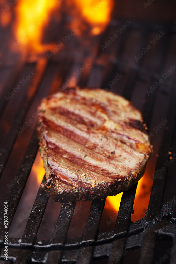 ribeye rib eye roast beef steak on bbq barbecue grill with flame