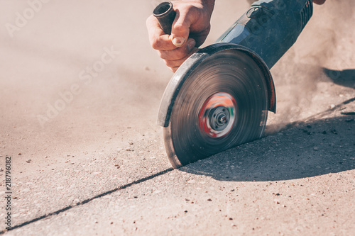 Photo A close-up of a working angle grinder with a diamond disc