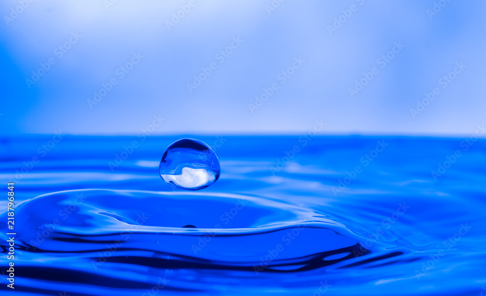 single water drop splashing in a body of water single water drop splashing in a body of water