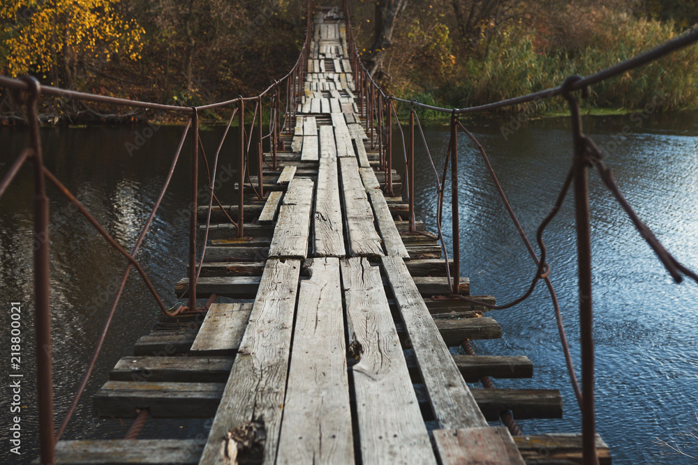 Old abandoned wooden bridge across river