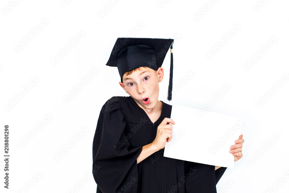 A boy in a student hat holding an empty Billboard . Knowledge, education and successful career.Isolated on white background.Portrait of a confident smart boy. A boy in a student hat holding an empty Billboard . Knowledge, education and successful career.Isolated on white background.Portrait of a confident smart boy.