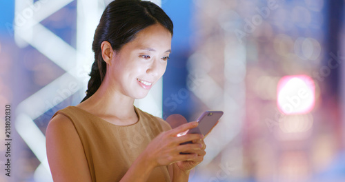 Wallpaper Mural Woman use of smart phone in city at night Torontodigital.ca