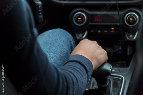 Man's hand on car speed shift knob