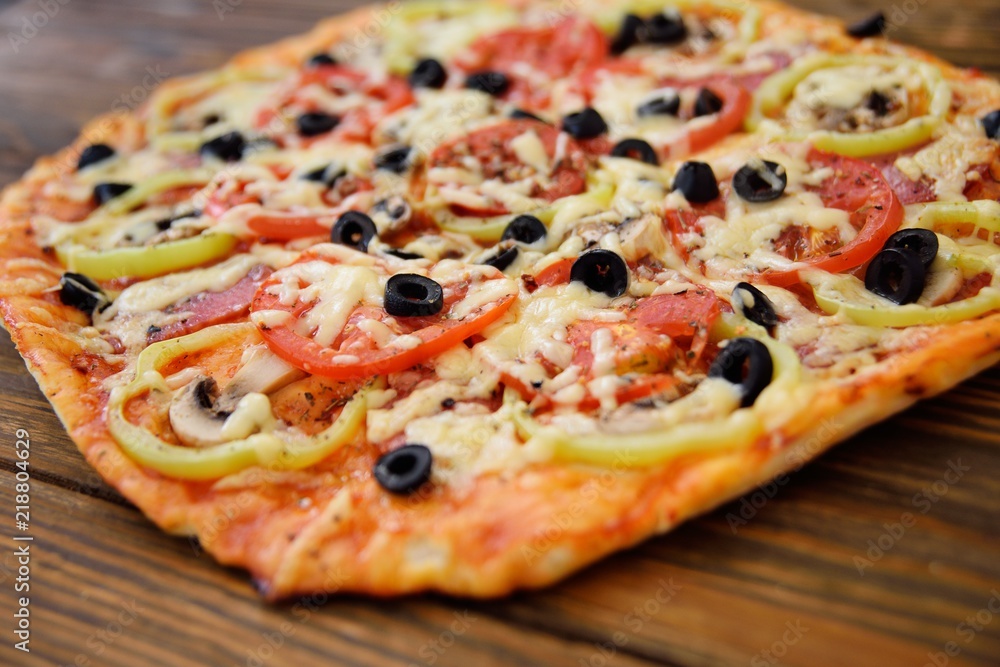 Preparation of homemade pizza with salami, mushrooms, olives, tomatoes and greens Preparation of homemade pizza with salami, mushrooms, olives, tomatoes and greens