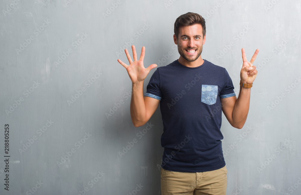 Handsome young man over grey grunge wall showing and pointing up with fingers number seven while smiling confident and happy. Handsome young man over grey grunge wall showing and pointing up with fingers number seven while smiling confident and happy.
