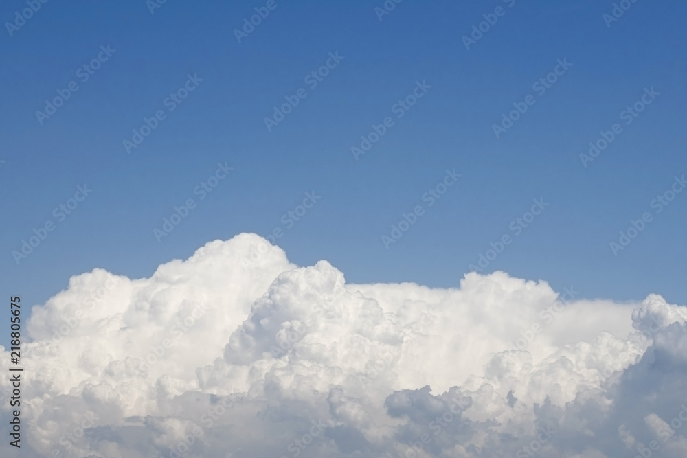 white fluffy and voluminous clouds on a clear blue summer sky white fluffy and voluminous clouds on a clear blue summer sky