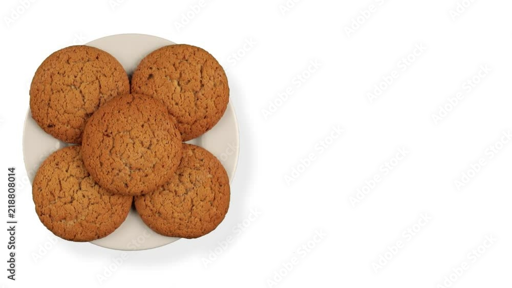 A stack of cookies rotates. A few biscuits on a rotating plate. A plate on a white background. View from above. A stack of cookies rotates. A few biscuits on a rotating plate. A plate on a white background. View from above.