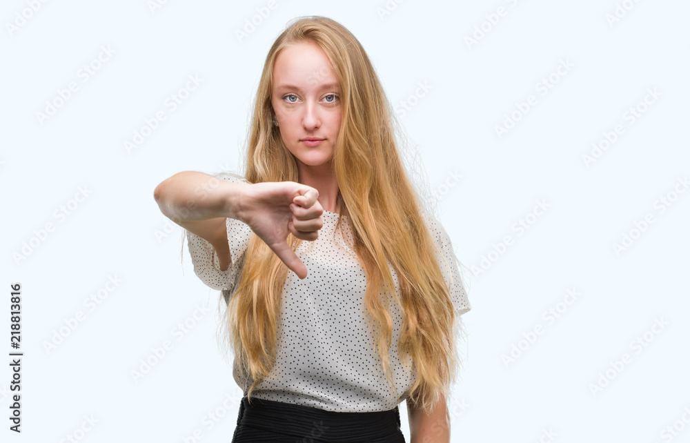 Blonde teenager woman wearing moles shirt looking unhappy and angry showing rejection and negative with thumbs down gesture. Bad expression. Blonde teenager woman wearing moles shirt looking unhappy and angry showing rejection and negative with thumbs down gesture. Bad expression.