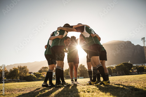 Canvas Print Rugby players huddling on sports field