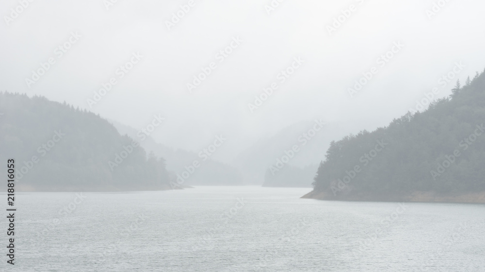Bright hazy landscape view of Zaovine lake in rainy foggy weather in Tara national park, Serbia Bright hazy landscape view of Zaovine lake in rainy foggy weather in Tara national park, Serbia
