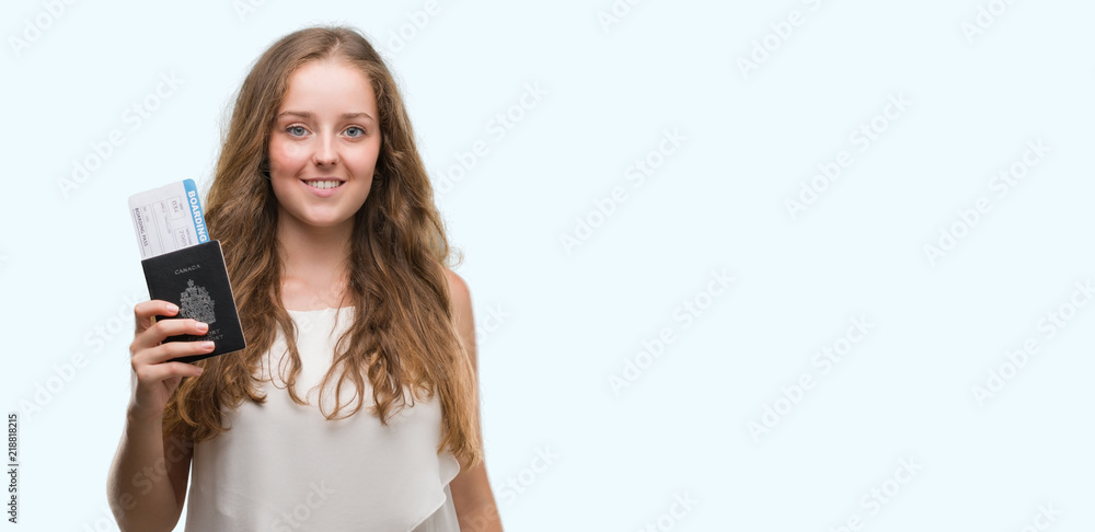Young blonde woman holding passport of canada and boarding pass with a happy face standing and smiling with a confident smile showing teeth Young blonde woman holding passport of canada and boarding pass with a happy face standing and smiling with a confident smile showing teeth