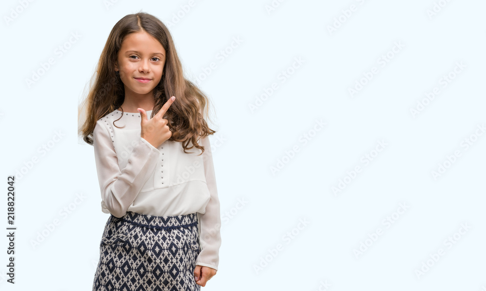 Brunette hispanic girl cheerful with a smile of face pointing with hand and finger up to the side with happy and natural expression on face looking at the camera. Brunette hispanic girl cheerful with a smile of face pointing with hand and finger up to the side with happy and natural expression on face looking at the camera.