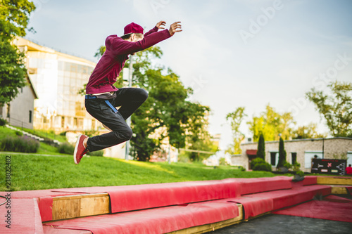 young man freerun in summer city public park running, jumping and flying, parkour concept © Mihail
