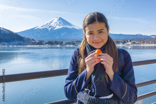 Asia woman tourist or traveler is traveling into Lake Kawaguchiko in Japan on winter.