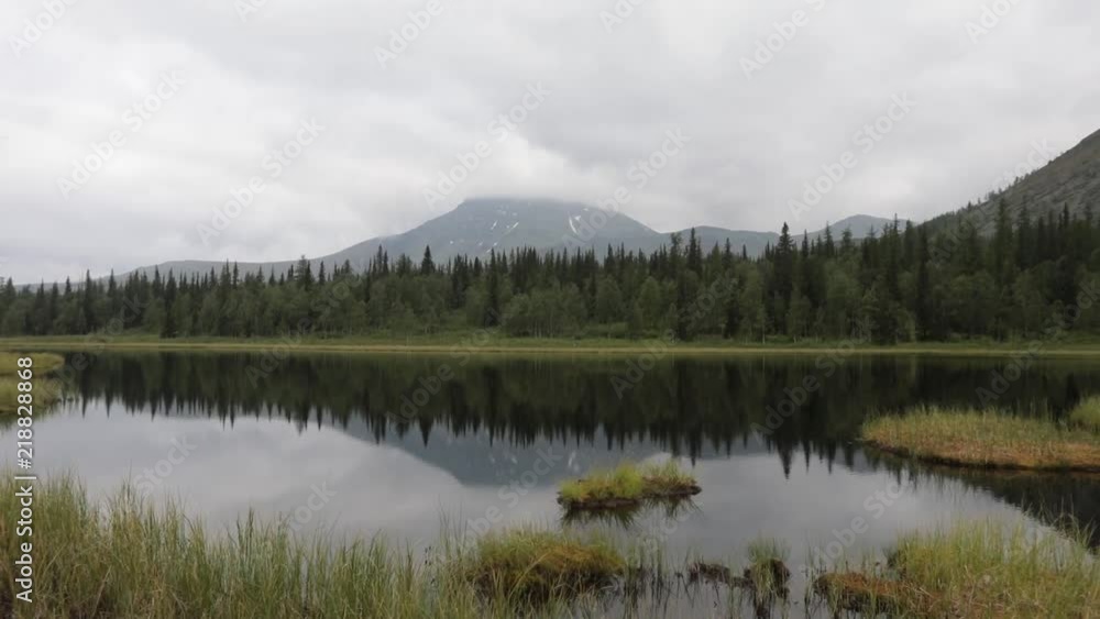 Quiet tranquil mountain lake. Reflection of green peaks in water Quiet tranquil mountain lake. Reflection of green peaks in water