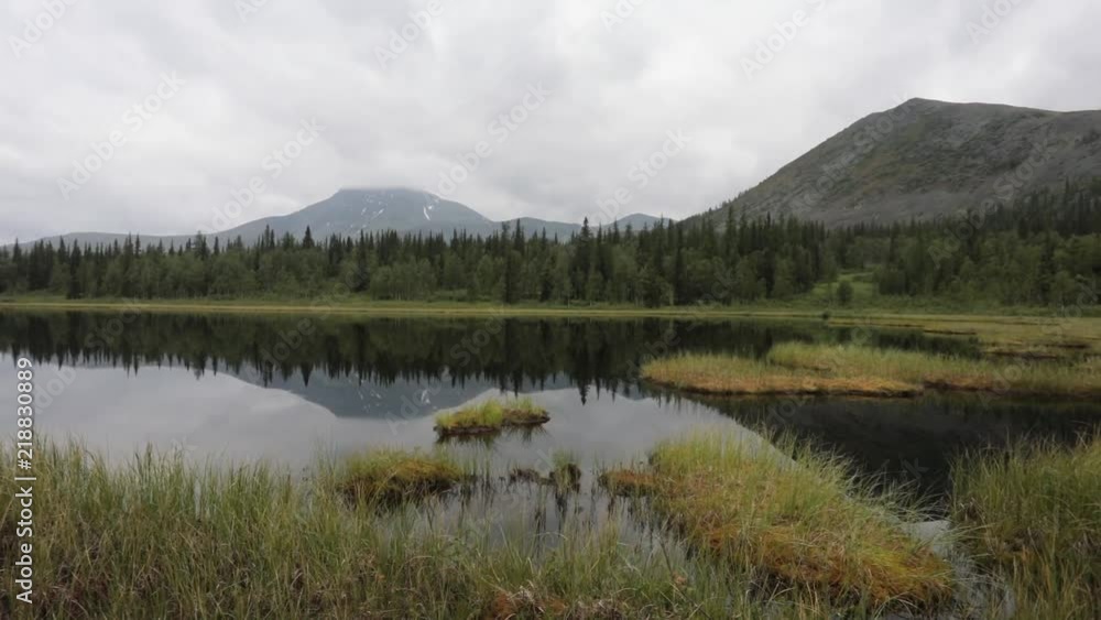 Quiet tranquil mountain lake. Reflection of green peaks in water Quiet tranquil mountain lake. Reflection of green peaks in water