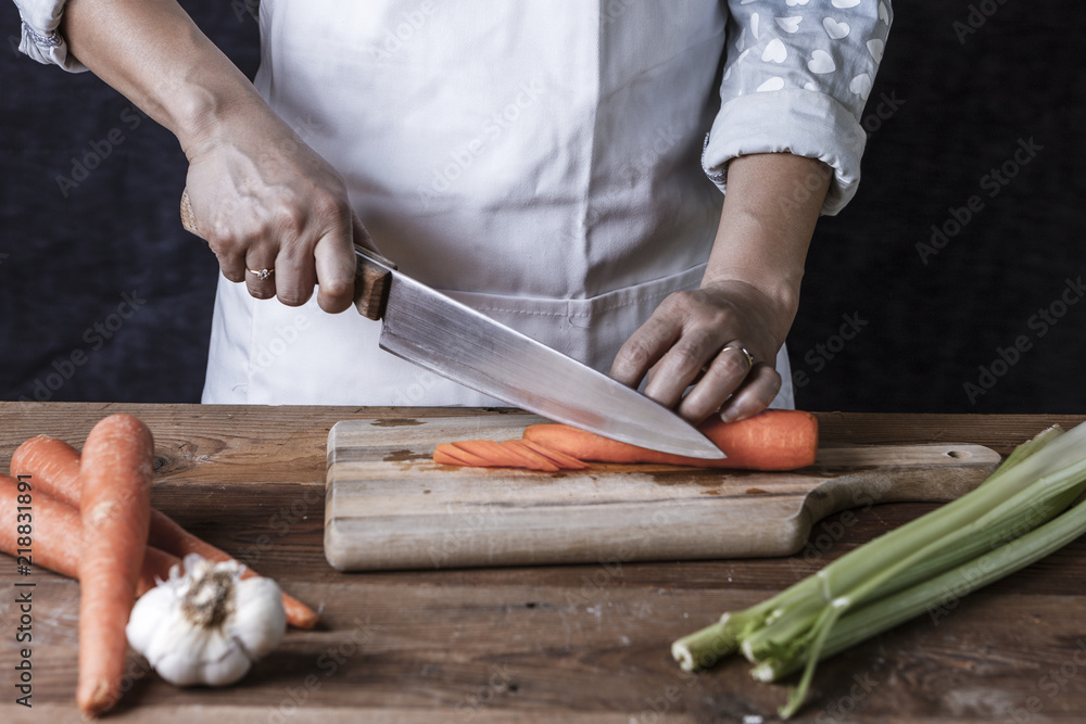 Fotografie Slicing carrots on a cutting board.