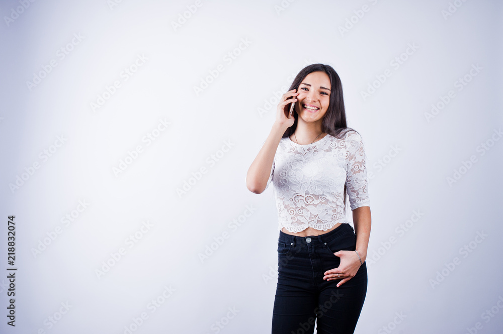 Portrait of a young beautiful woman in white top and black pants using her phone. Portrait of a young beautiful woman in white top and black pants using her phone.