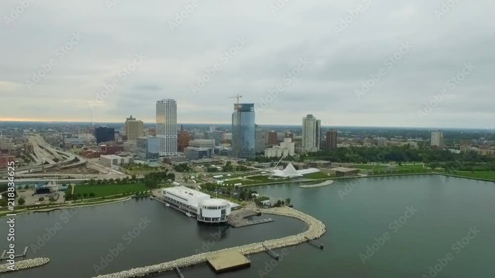 A slow motion aerial drone clip in slow motion shows off the harbor, highways and lakefront skyline of Milwaukee, Wisconsin, as a storm moves over the city at sunset. A perfect establishing shot. A slow motion aerial drone clip in slow motion shows off the harbor, highways and lakefront skyline of Milwaukee, Wisconsin, as a storm moves over the city at sunset. A perfect establishing shot.