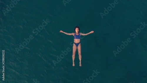 Wallpaper Mural AERIAL SLOW MOTION: woman floating on blue water surface, swimming in transparent mediterranean sea, top down view, summer vacation concept Torontodigital.ca
