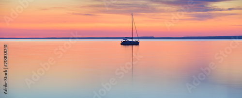 Obraz na plátně The world at rest - sailing boat in calm lake at sunset