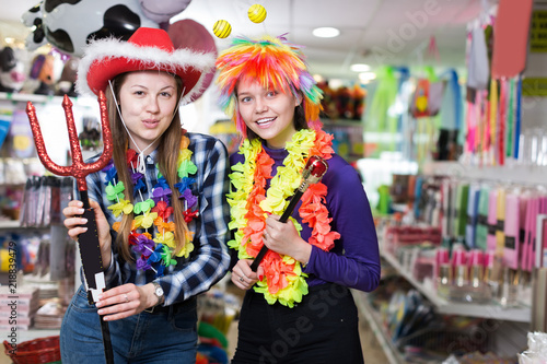 Two smiling girls friends having fun in festival outfits store